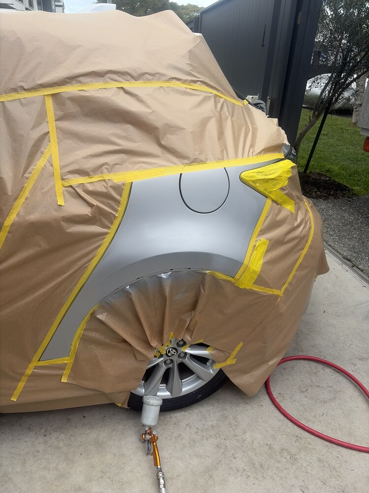 Rear quarter panel masked off for a colour matched respray on a driveway in Brisbane